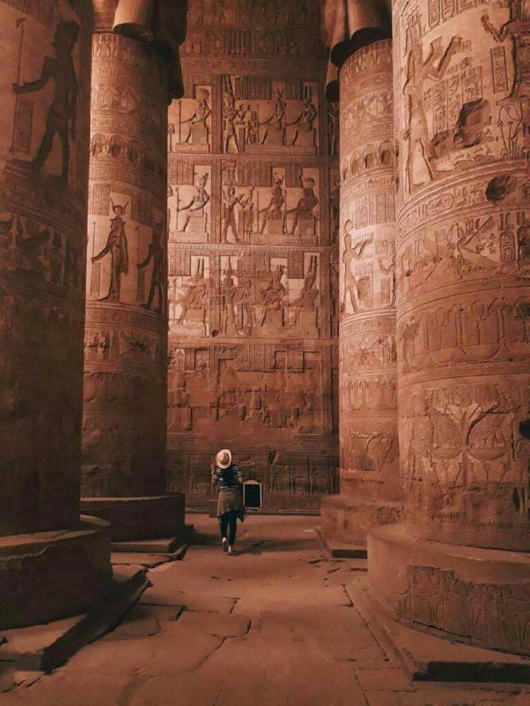 una donna con cappello passeggia per le aree archeologiche dell'egitto